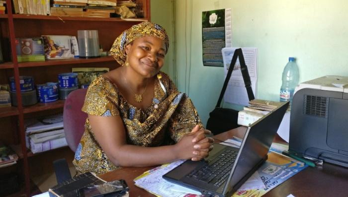 Kamerunilainen Asta Sabia istuu työpöytänsä ääressä.