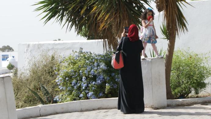 Valokuvaava nainen ja pikkutyttö Tunisiassa.