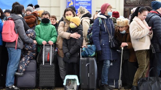 Ihmisiä matkalaukkuineen Lvivin rautatieasemalla, Ukrainassa.