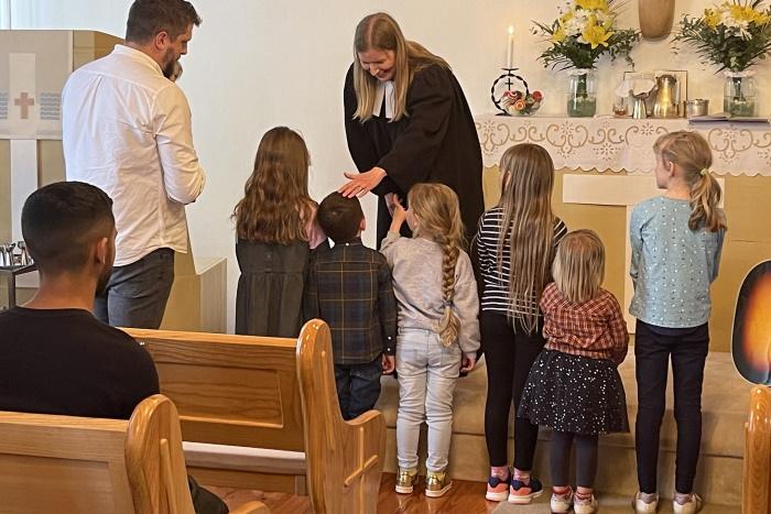 Elina-pappi siunaa lapsia alttarilla.