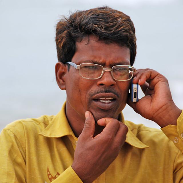 Intialainen mies puhuu kännykkään.