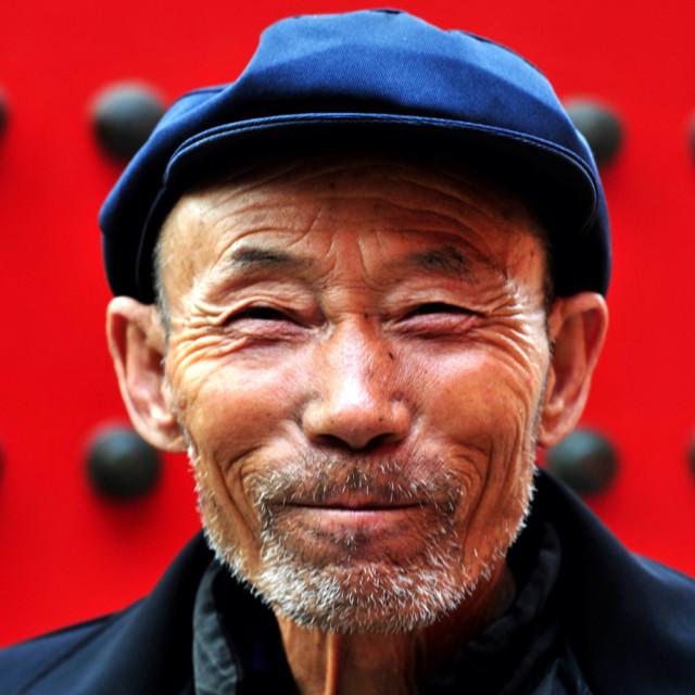 Hymyilevä kiinalainen mies.