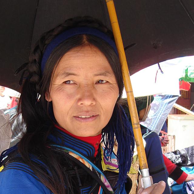 Kiinalainen nainen sateenvarjon alla.