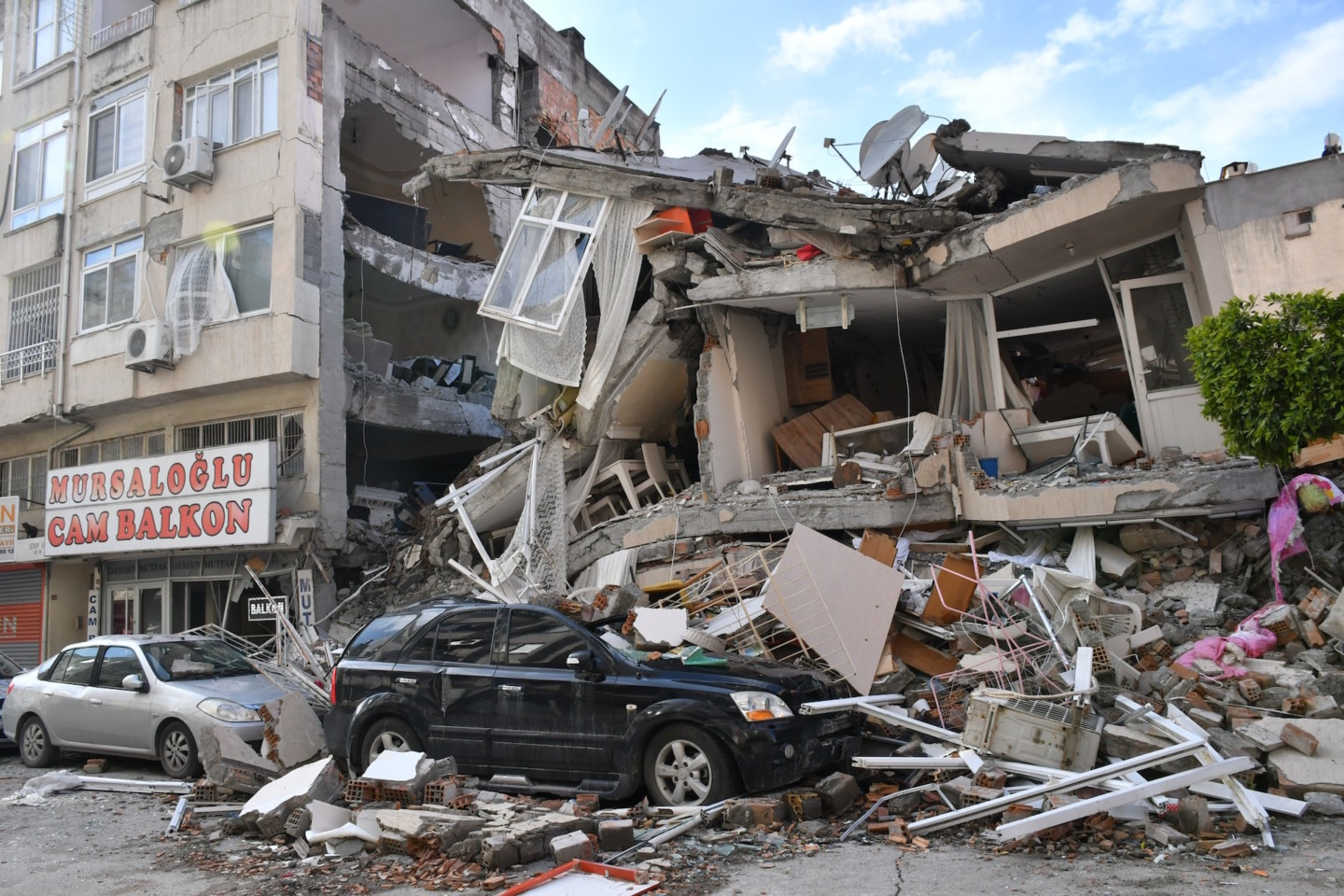 Iskenderunin kaupungin katunäkymää ja romahtanut talo Turkissa maanjäristyksen jälkeen.