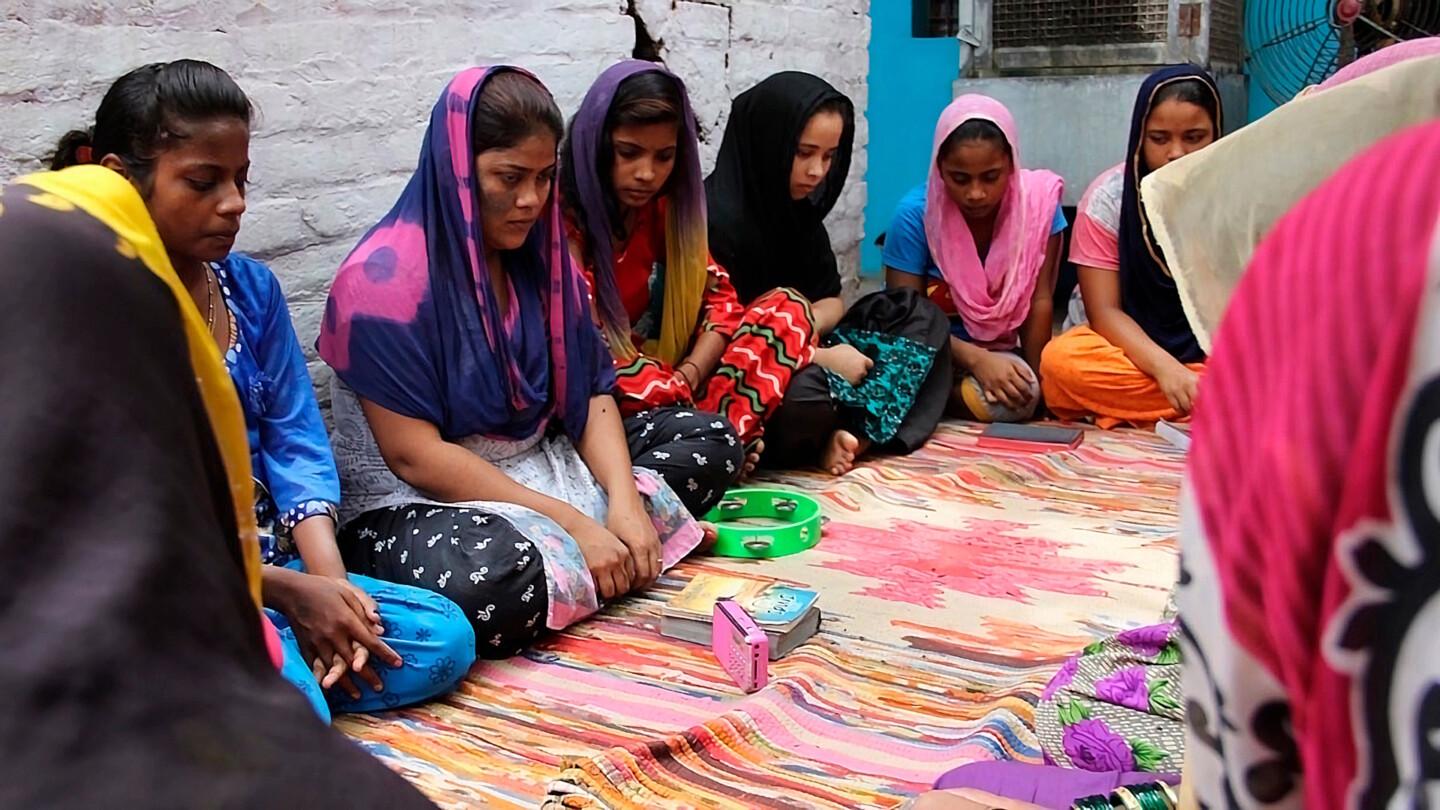 Intialaiset naiset kuuntelevat keskittyneesti kristillistä radio-ohjelmaa.