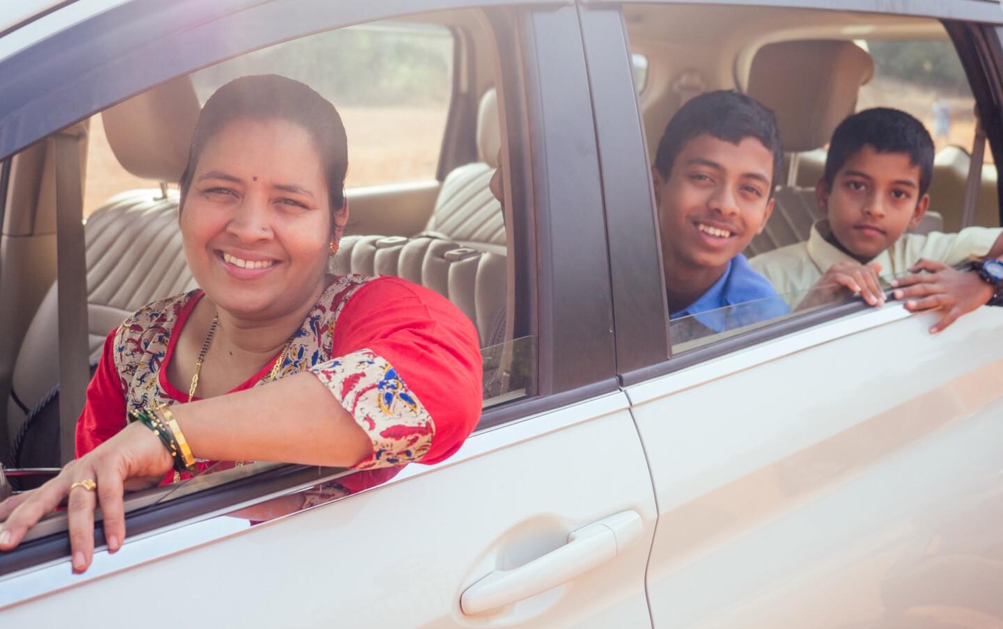 Intialaiset äiti ja pojat autossa.