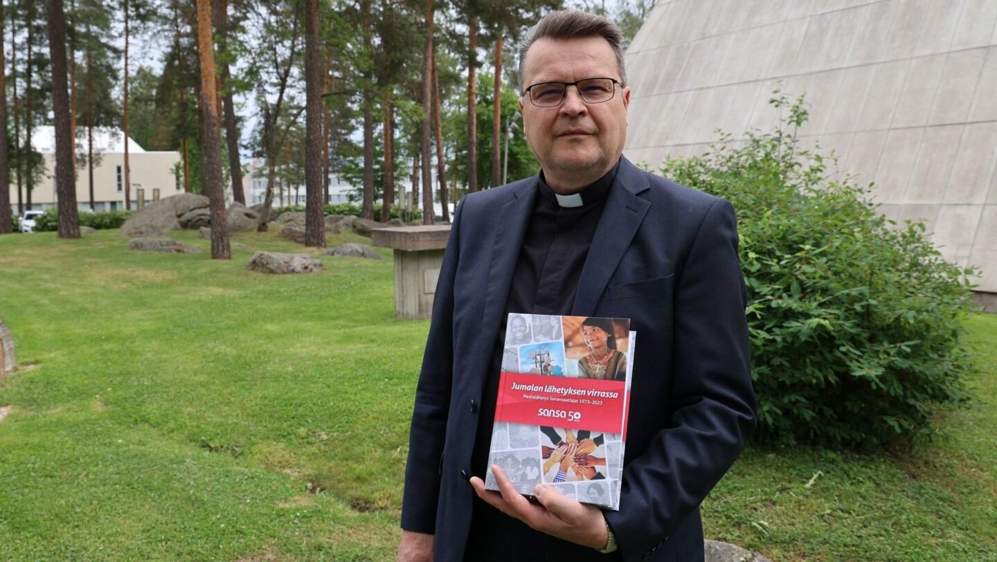 Juha Koivulahti pitelee kädessään Sansan 50-vuotishistoriateosta.