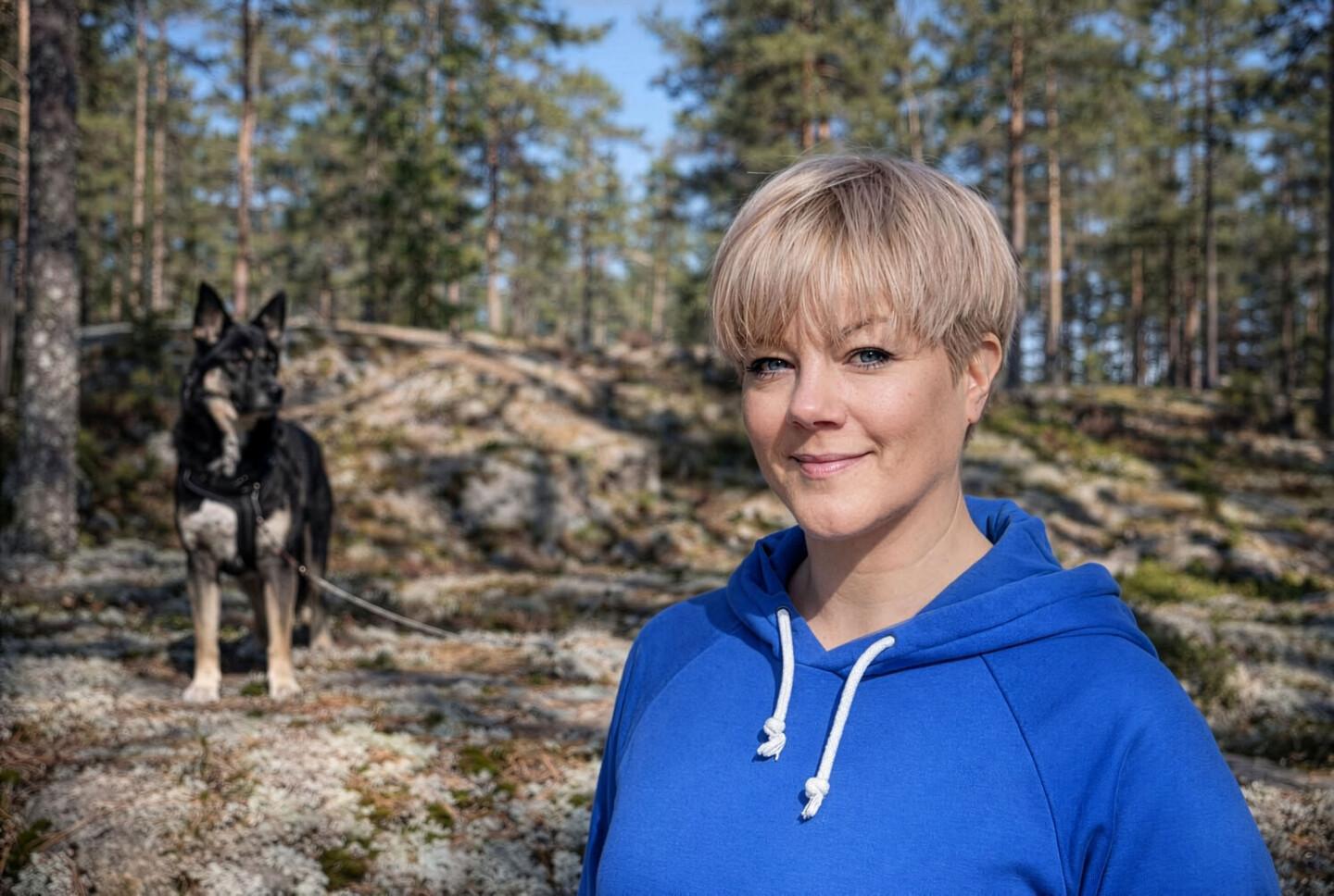 Laura Tulisalo ja koira metsässä.